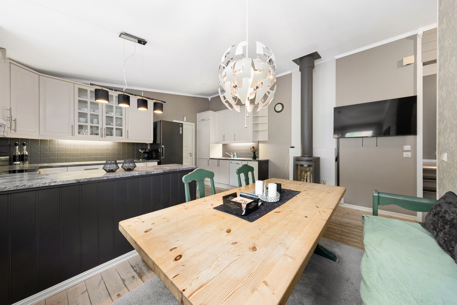 Her er det plass til både frittstående komfyr med platetopp og kjøleskap, og det er i tillegg montert vedovn som gir både varme og en hyggelig atmosfære. Galleribilde