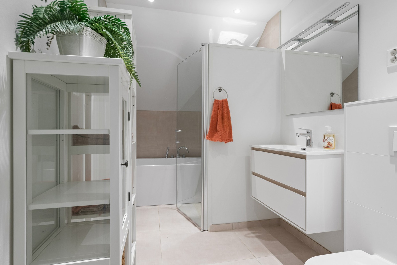 Delikat bad med store fliser, downlights og en praktisk nisje med badekar og regnfallsdusj. Galleribilde