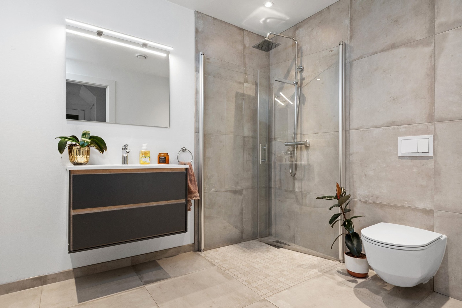 Badet i første etasje er både funksjonelt og delikat, med dusjhjørne og vaskemaskinopplegg. Galleribilde