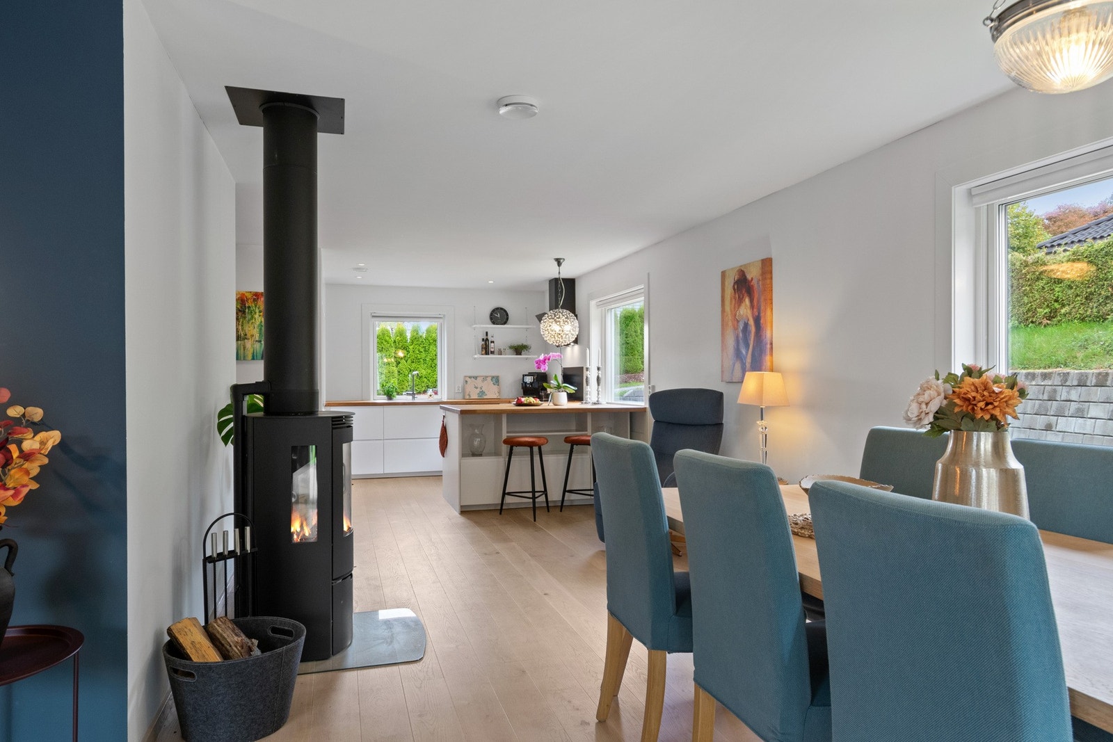 Lyst og moderne kjøkken med heltre benkeplate, integrerte hvitevarer og en stor barløsning. Galleribilde