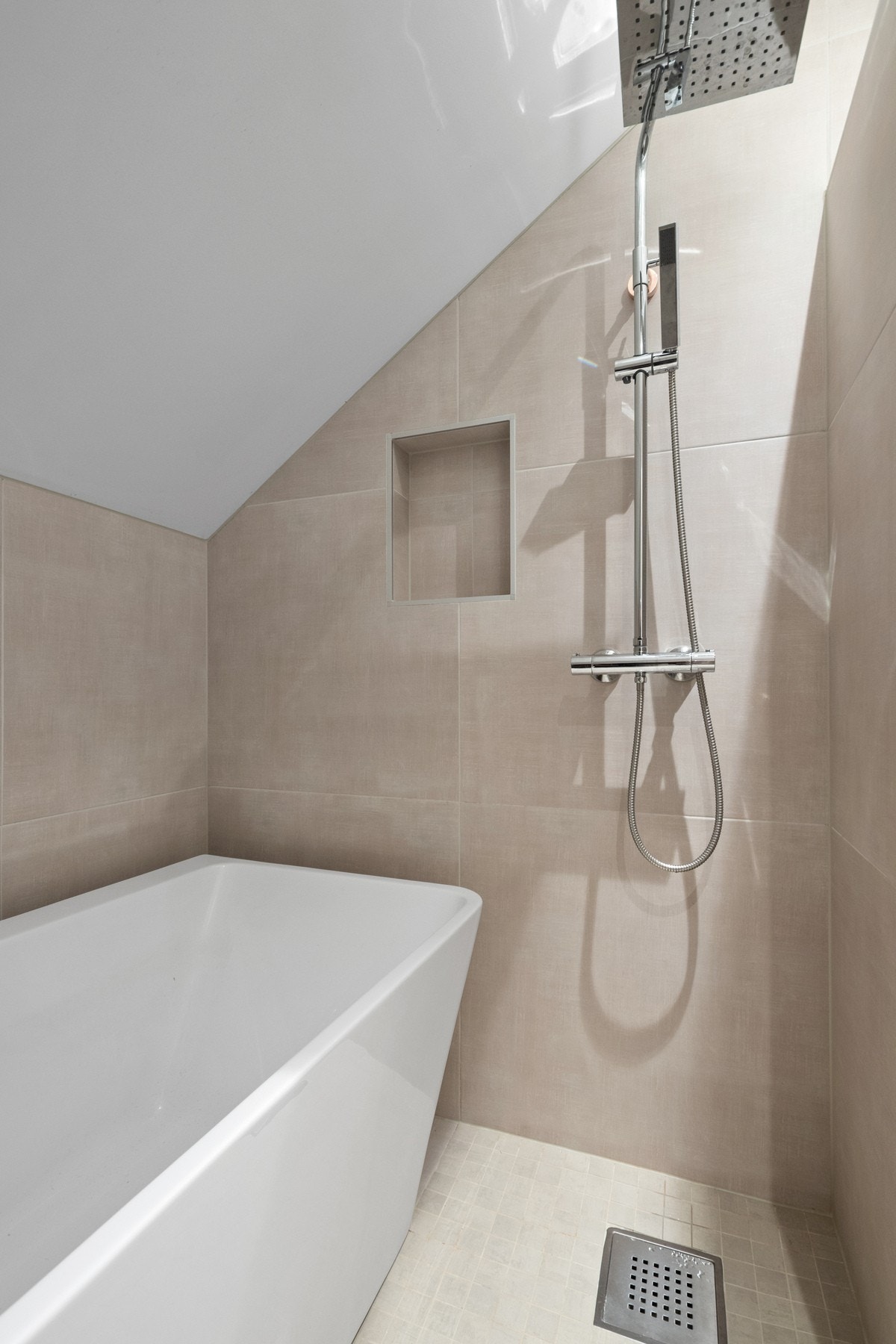 Et moderne bad som kombinerer funksjonalitet og komfort, med innredning i stilrene materialer. Galleribilde