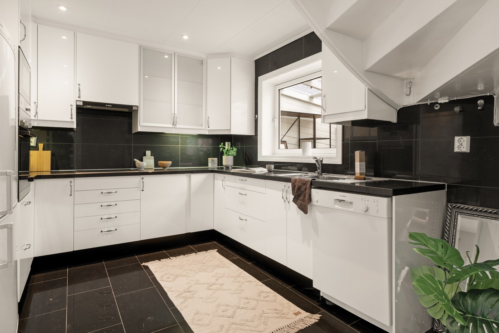 Ikea kjøkkeninnredning med hvite glatte fronter og laminert benkeplate med planlimt kjøkkenbeslag. Galleribilde