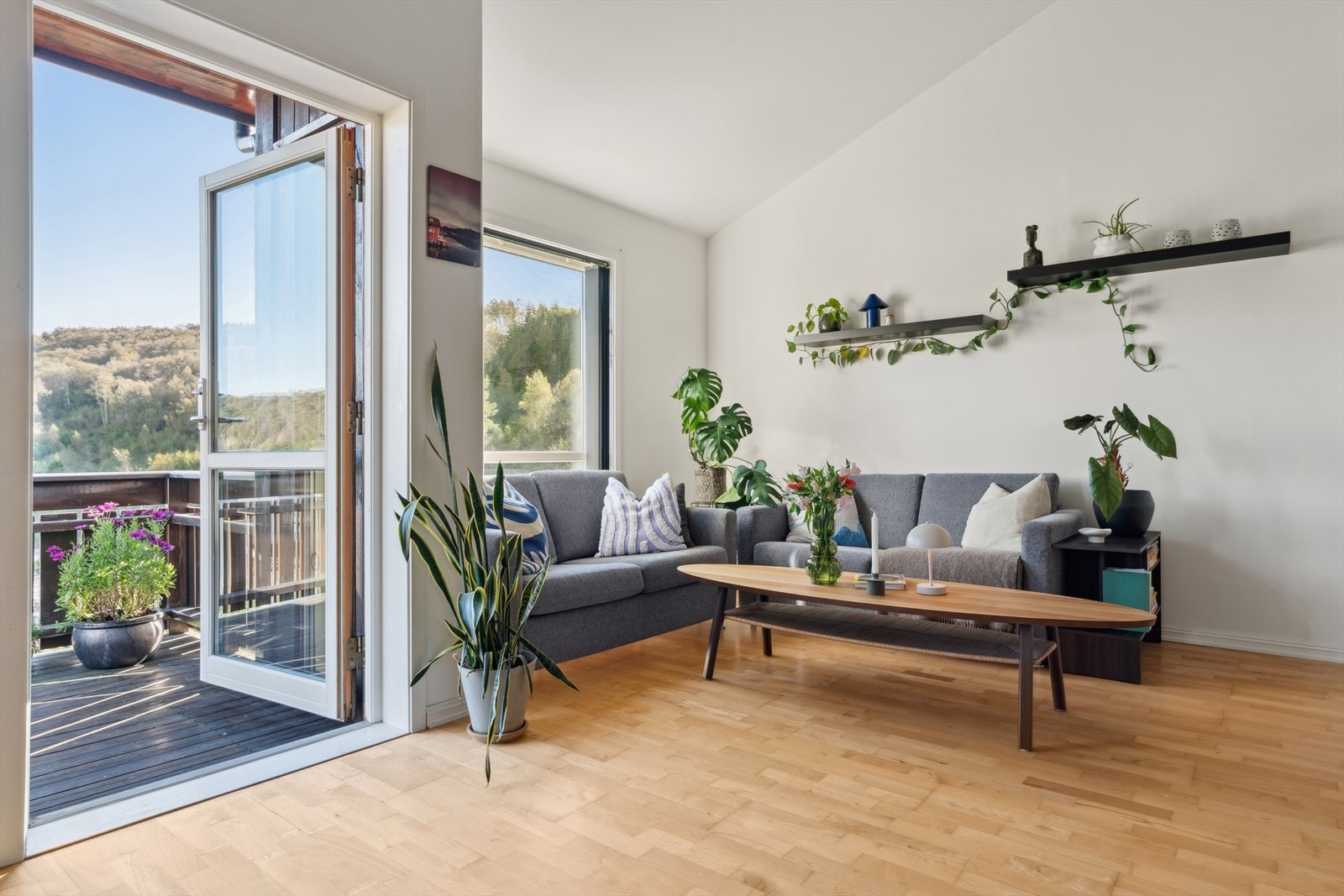 Leiligheten har et lyst oppholdsrom med åpen løsning mellom stue og kjøkken. Galleribilde