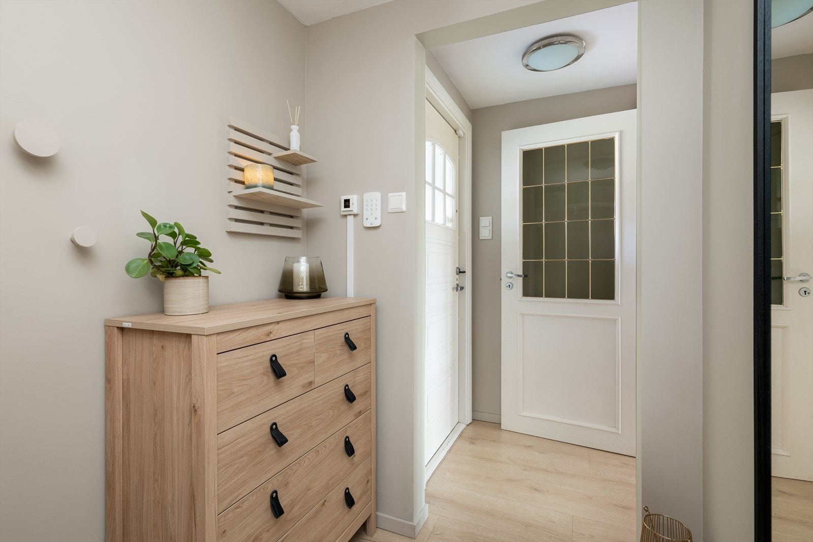 Med adkomst fra det hyggelige inngangspartiet kommer man inn i boligens entrè, med nyere, moderne laminatgulv som går videre inn i etasjen og gir et helhetlig inntrykk. Galleribilde