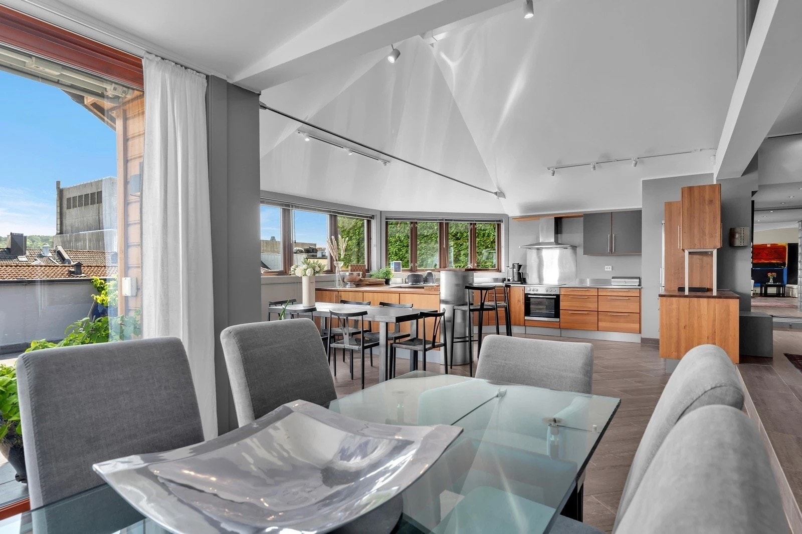 Spiseplass med flott utsyn mot kjøkkenet og store vindusflater som slipper inn mye naturlig lys. Galleribilde