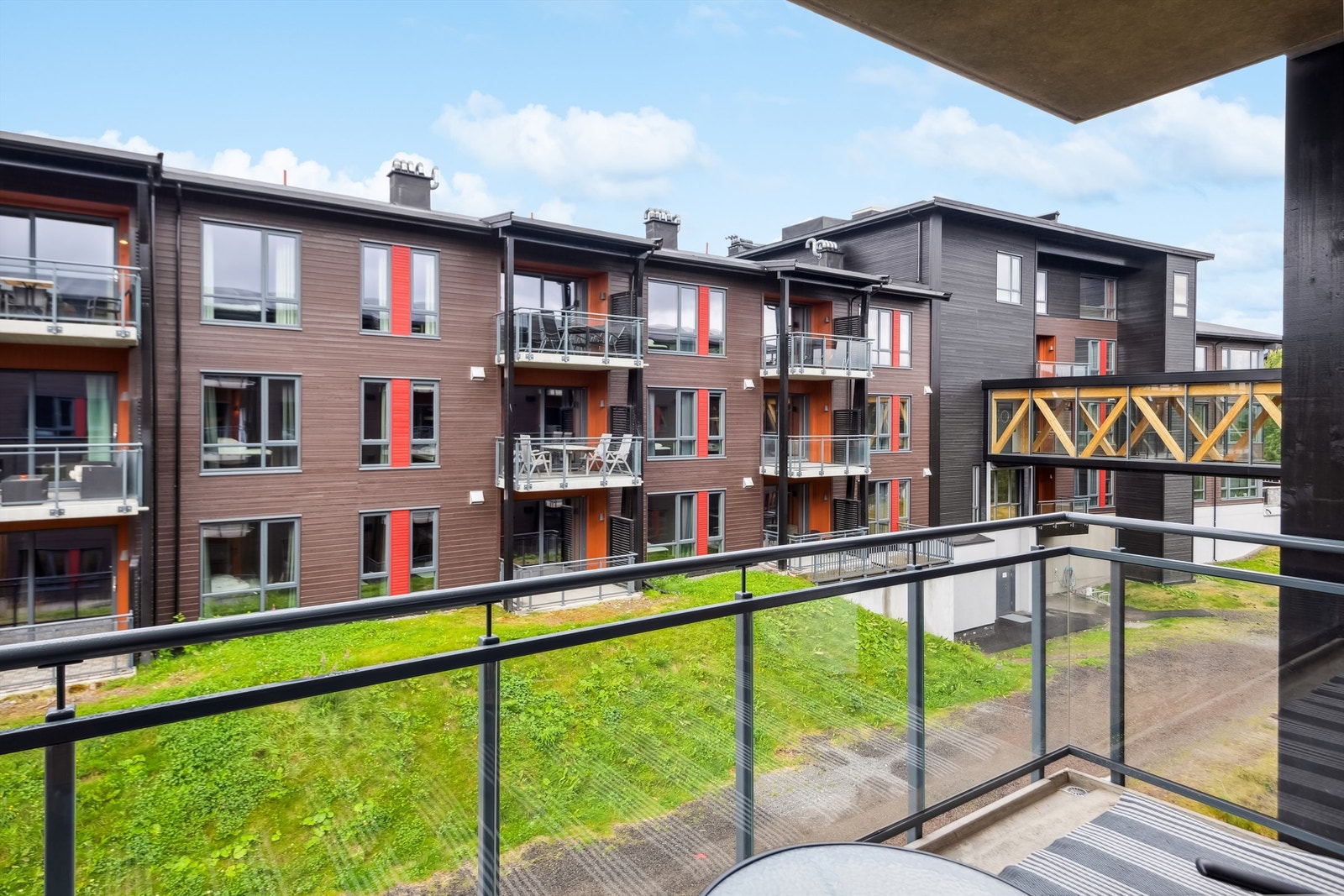 Utsikt fra balkong. Parkeringskjeller i nabobygget, med heis og adkomst via gangbru mellom byggene. Galleribilde