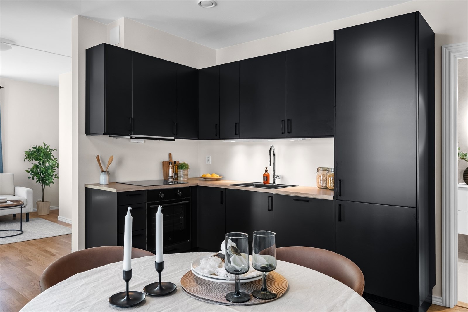 Lekkert kjøkken fra 2024 med mye skap- og benkeplass. Norema kjøkkeninnredning med glatte fronter i mørk utførelse, laminat benkeplate med nedfelt vask i kompositt og belysning under overskap for godt arbeidslys. Galleribilde