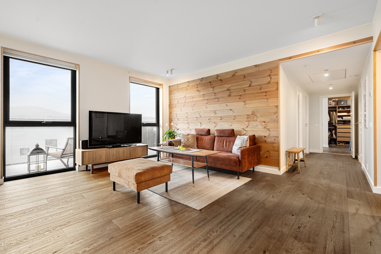 Stue med god plass, store vindusflater og naturlig lys Galleribilde