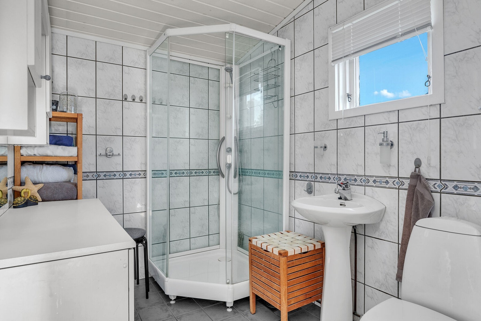 Helfliset bad som ble overflateoppusset i 2004, og med elektriske varmekabler i gulv. Rommet har innredning med servant, wc og dusjkabinett. Galleribilde