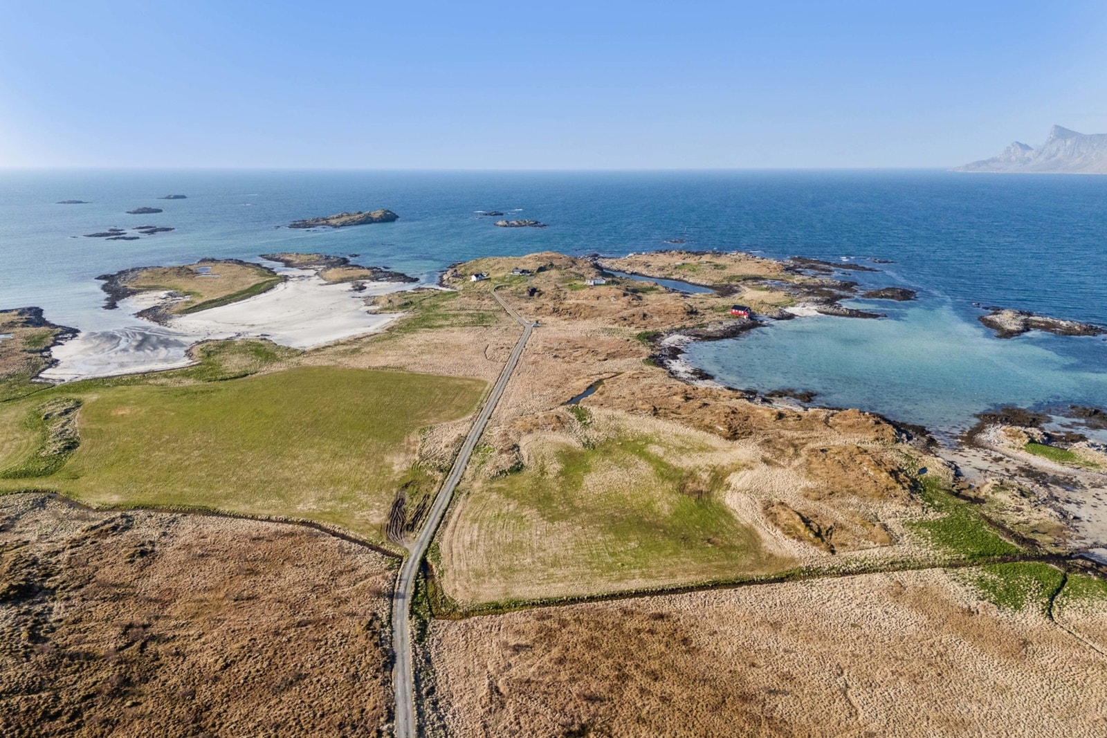 Eiendommen har en virkelig spektakulær beliggenhet på Korshamn like utenfor Fredvang i Flakstad kommune. Her er storhavet og kritthvite strender nærmeste nabo. Galleribilde