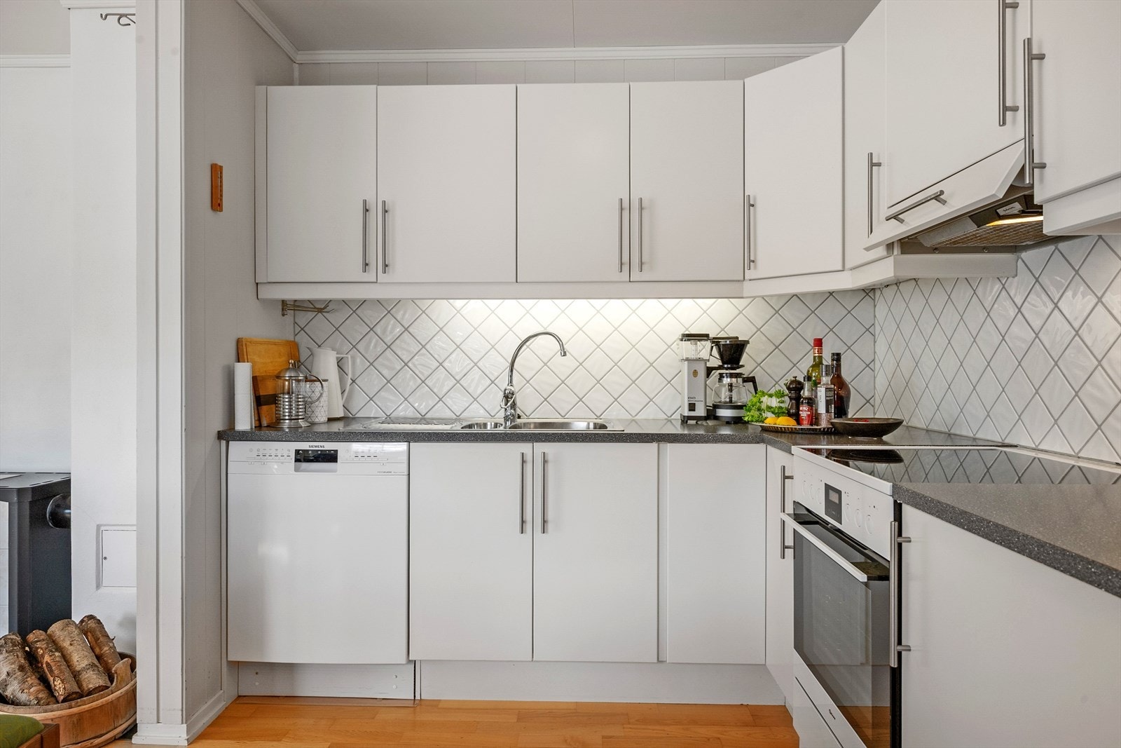 Benkeplaten er av laminat og det er frittstående hvitevarer. Galleribilde