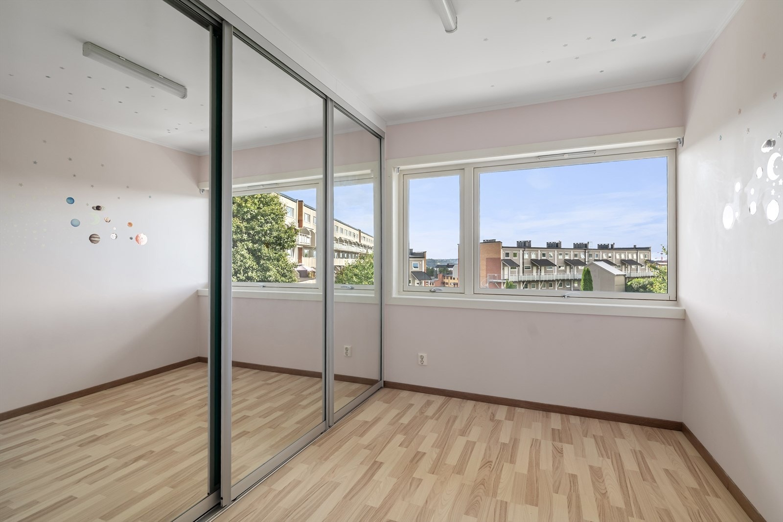 Lyst og romslig hovedsoverom innredet med stor skyvedørsgarderobe Galleribilde