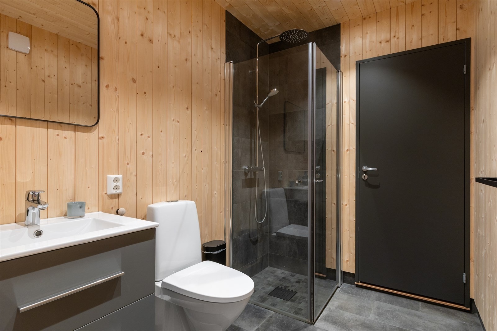 Moderne baderom med flislagt gulv med elektrisk gulvvarme, samt flislagte vegger kombinert med panel for et lunt preg. Galleribilde