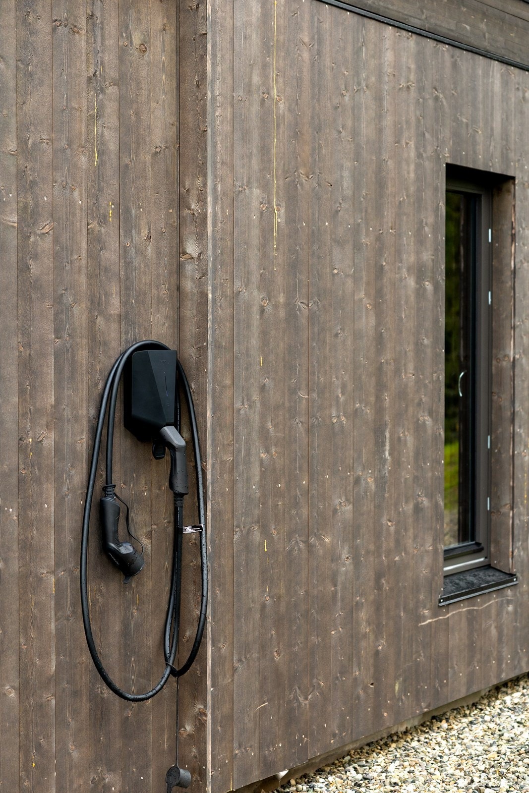 Fritidsboligen har en egen gruset gårdsplass med plass til flere biler, samt elbillader montert på yttervegg. Galleribilde