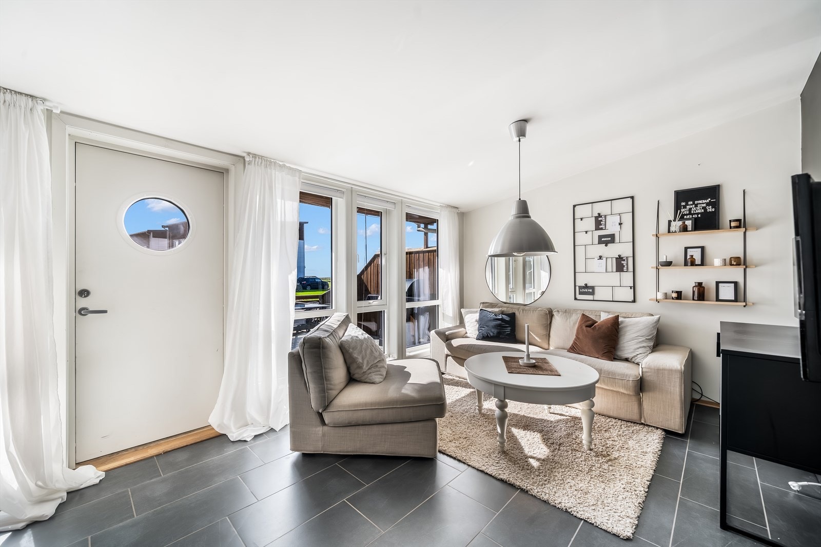 Del av stua som er innredet med sofakrok og tv. Galleribilde