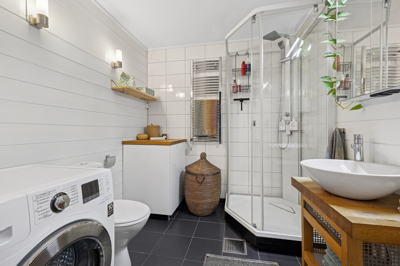 Badet er utstyrt med toalett, dusjkabinett, innredning med bolleservant og speilskap, samt opplegg for vaskemaskin. Galleribilde