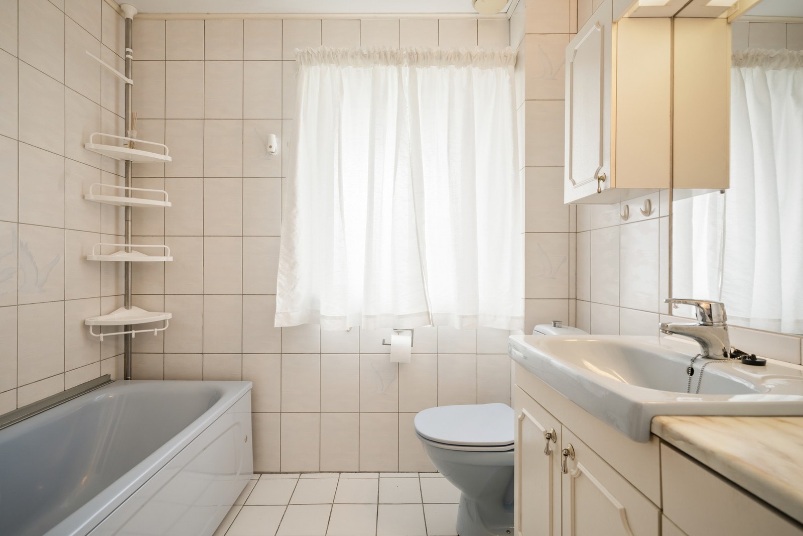 Fra entréen er det adkomst til bad med badekar, servant med skap, innmurt speil med lys, overskap og gulvmontert wc. Galleribilde