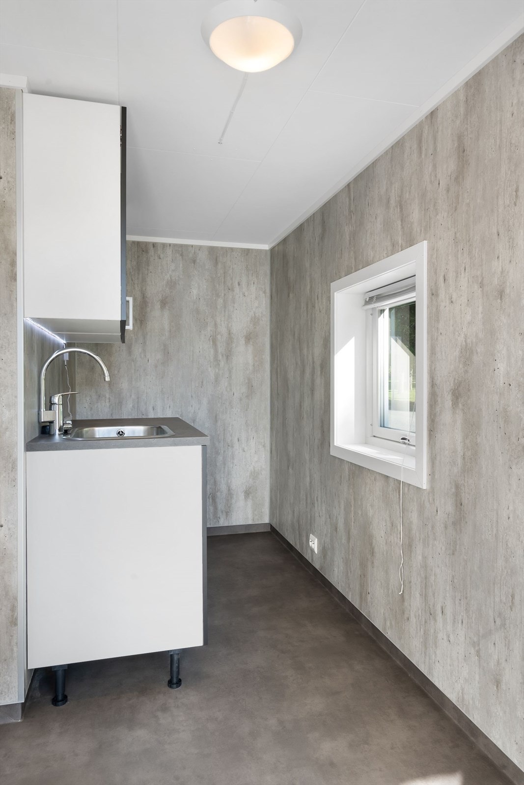 Fra vaskerom er det en inngangsdør mot sør. Der er det støpt trinn og det er overbygd tak. Galleribilde