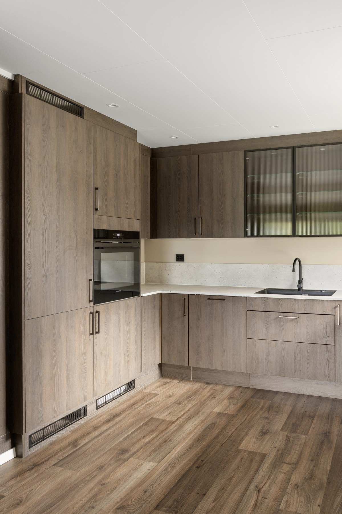 Pene detaljer som rillet glass på overskap, sort blandebatteri og sorte stikkontakter Galleribilde