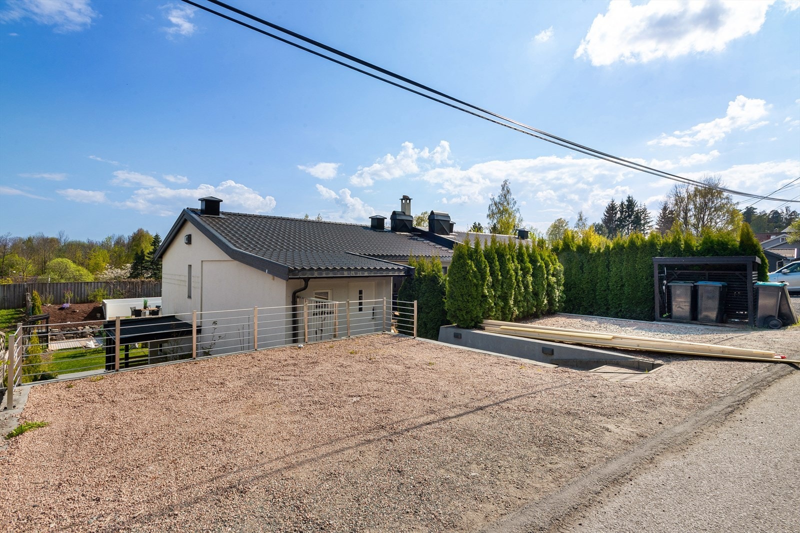 Gruset gårdsplass og trapper i belegningsstein og tre ned mot huset. Godkjent rammetillatelse for påbygg og carport. Galleribilde