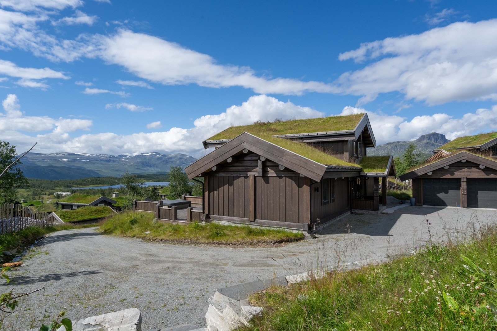 I det du kjører inn på eiendommen, møter man en representativ gårdsplass innrammet med flotte støttemurer i skifer. Bilen kan enkelt parkeres i oppvarmet garasje med plass til to biler.