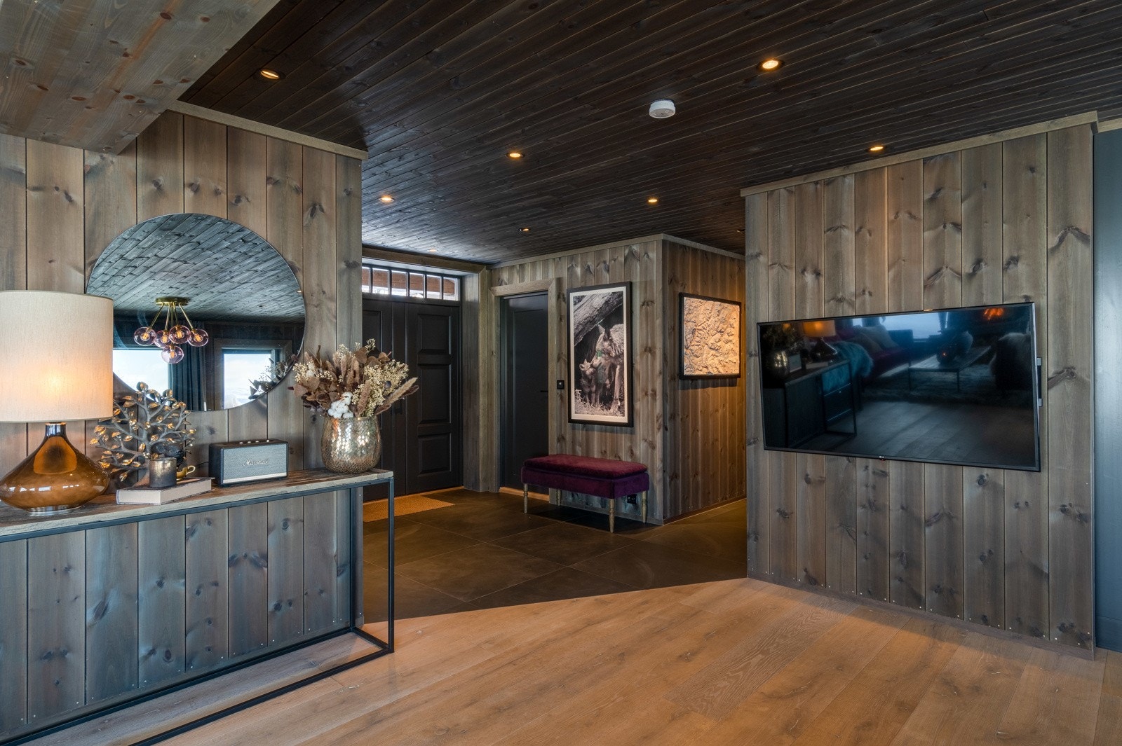 Entréen er romslig og innbydende med store gulvfliser, downlights og vannbåren gulvvarme. Videre inn møter man to gode soverom med hvert sitt bad.