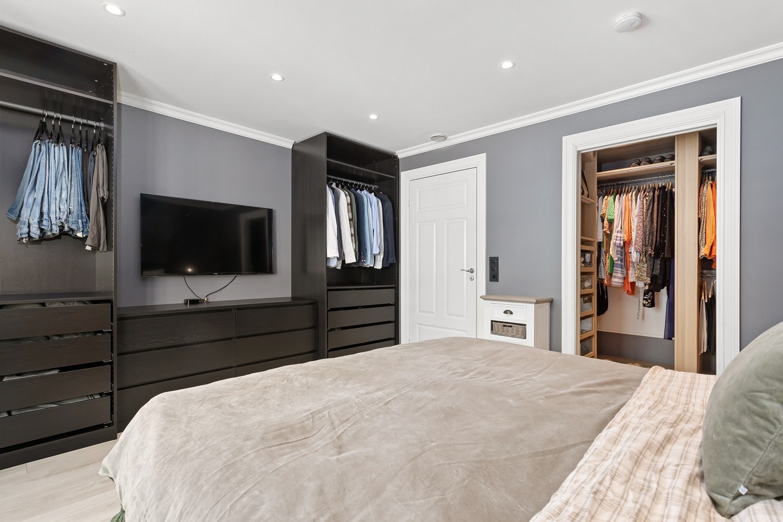 Rommet har også et eget garderoberom for praktisk klesoppbevaring, samt oppbevaring i åpne garderobeskap. Galleribilde