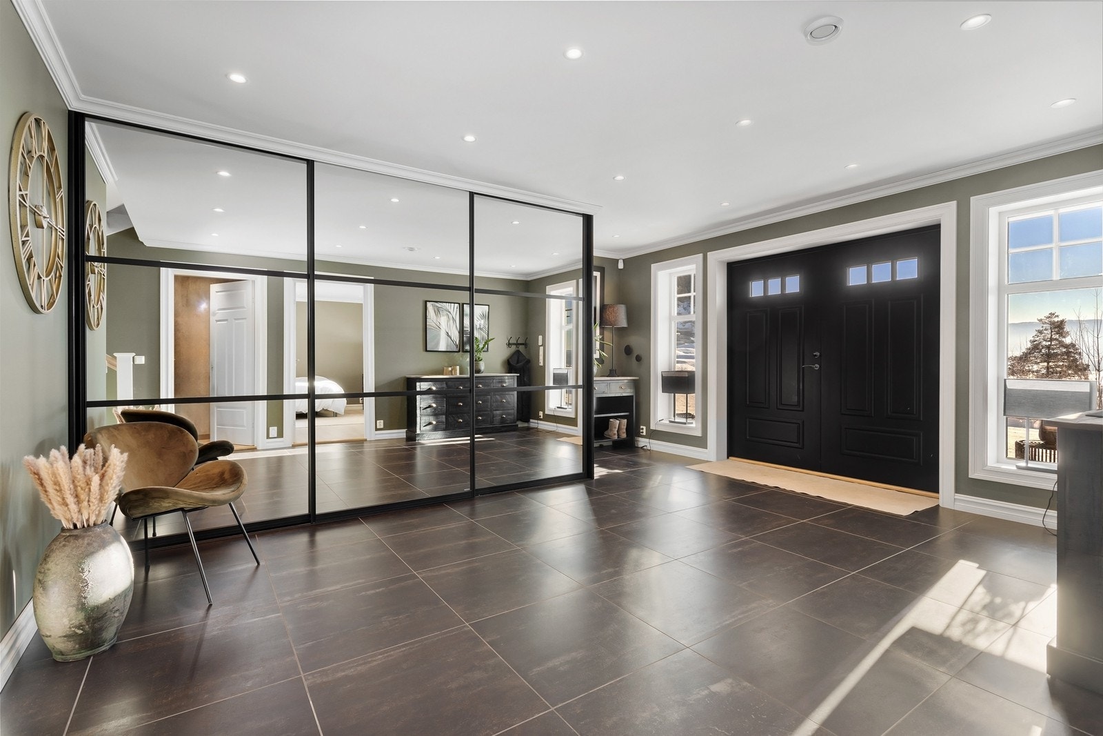 Hallen er romslig med fliser på gulv og vannbåren gulvarme. Det er gode oppbevaringsmuligheter i skyvedørsgarderobe som rommer hele familiens yttertøy. Velkommen inn! Galleribilde