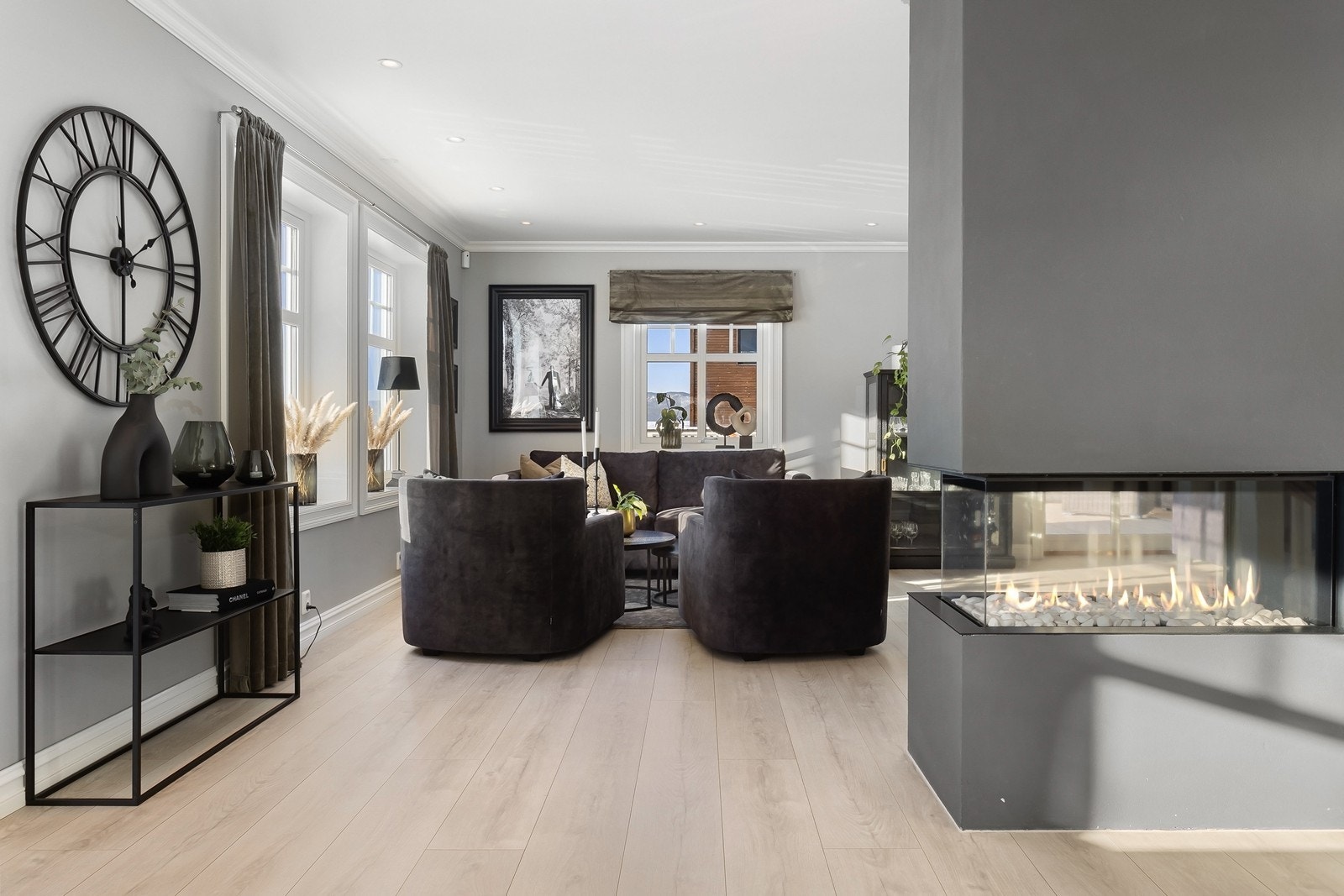 Som en romdeler er det installert en lekker gasspeis, som er malt i en mørkere gråtone enn de resterende veggene. Galleribilde