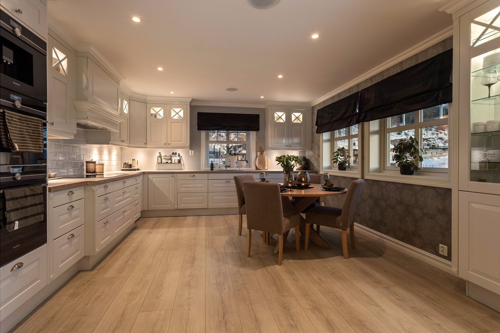 De profilerte og hvitlakkerte frontene gir innredningen et klassisk og tidløst design, og vitrinedører med glass og integrert belysning gir det lille ekstra. Galleribilde