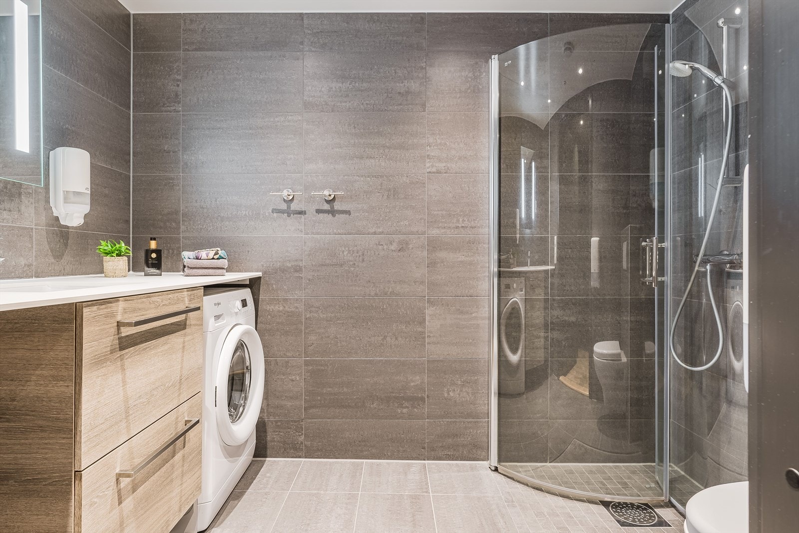 Baderommet er også utstyrt med dusjhjørne med innfellbare glassdører og vegghengt toalett. Galleribilde