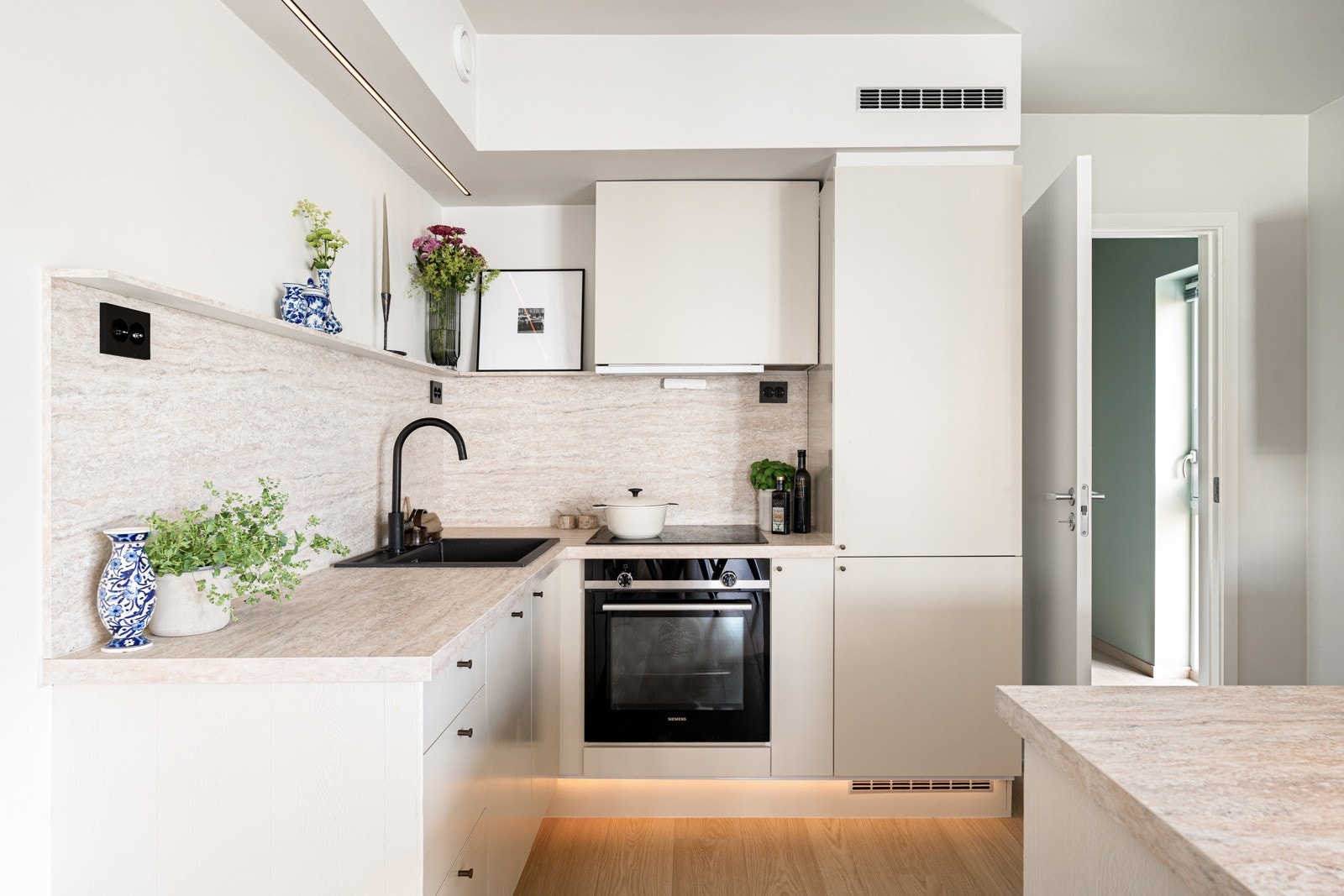 Leiligheten er innredet med et moderne kjøkken med minimalistisk utseende og sorte detaljer. Galleribilde