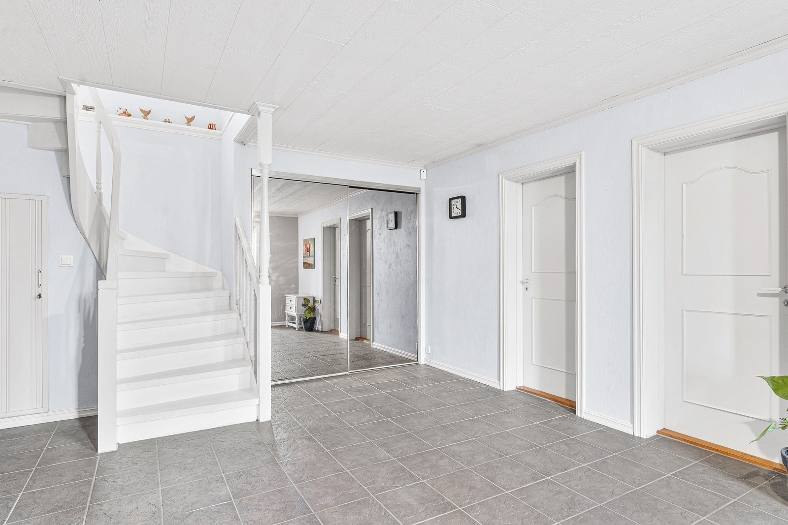 Romslig hall med gulvvarme og skyvedørsgarderobe som gir god oppbevaringsplass Galleribilde