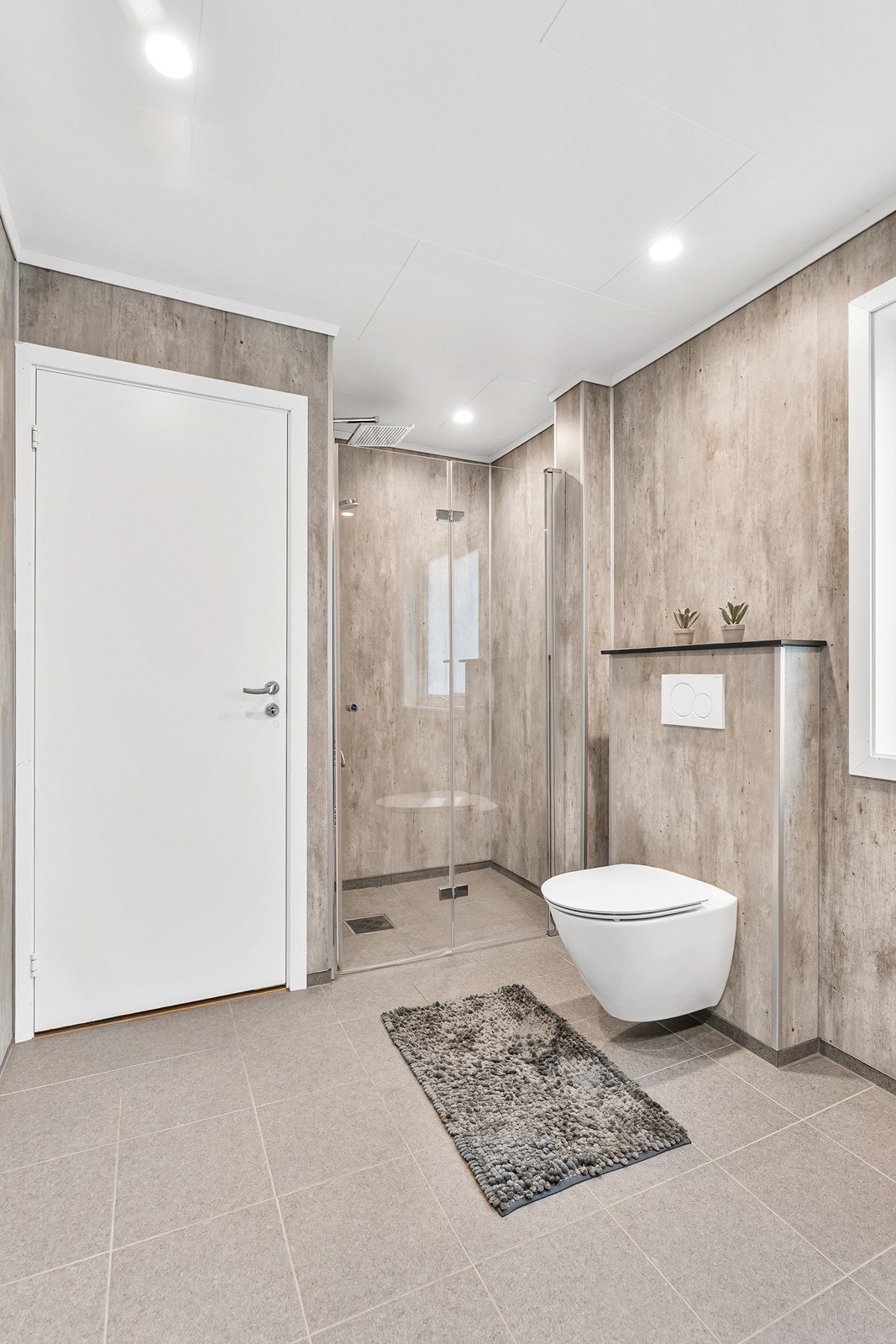 Badet er videre innredet med dusjhjørne, vegghengt toalett og baderomsinnredning med vask. Galleribilde