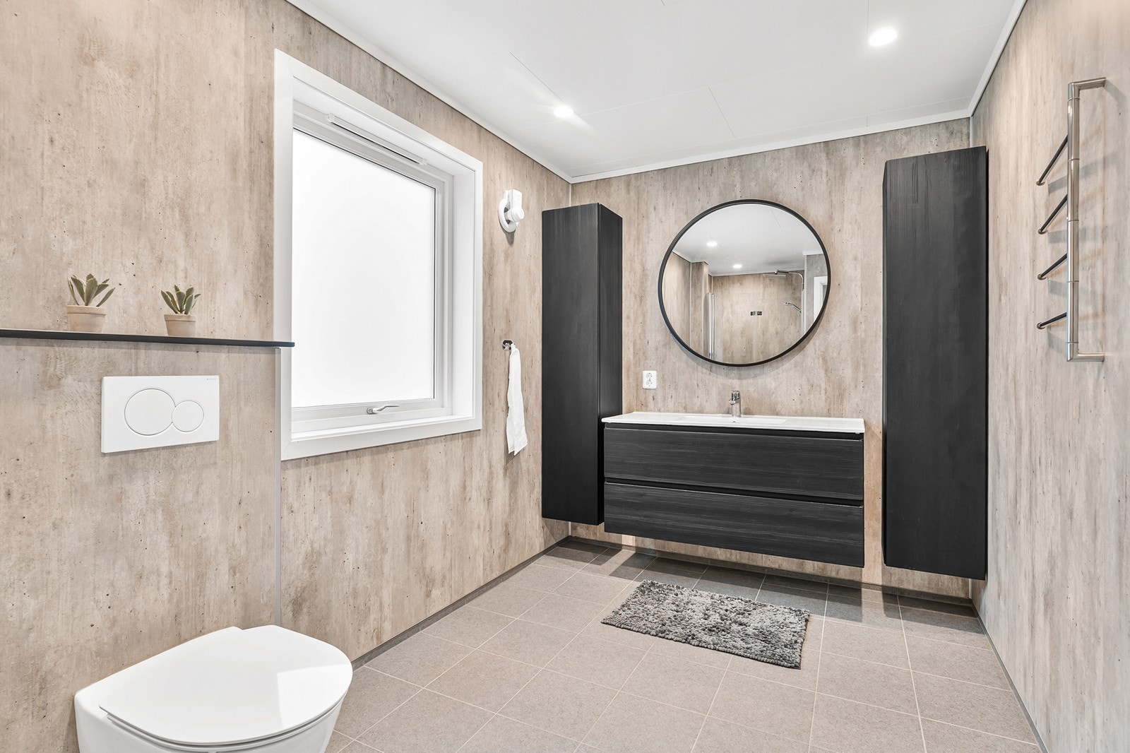 Bad har gulvfliser med varmekabler, baderomsplater på vegg og himlingsplater med spotter i tak Galleribilde