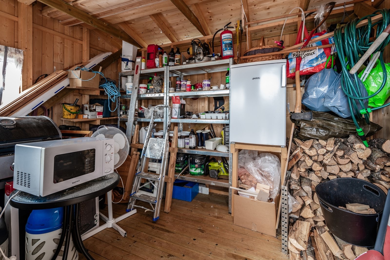 Romslig bod med god plass til oppbevaring av verktøy, ved og diverse utstyr. Galleribilde