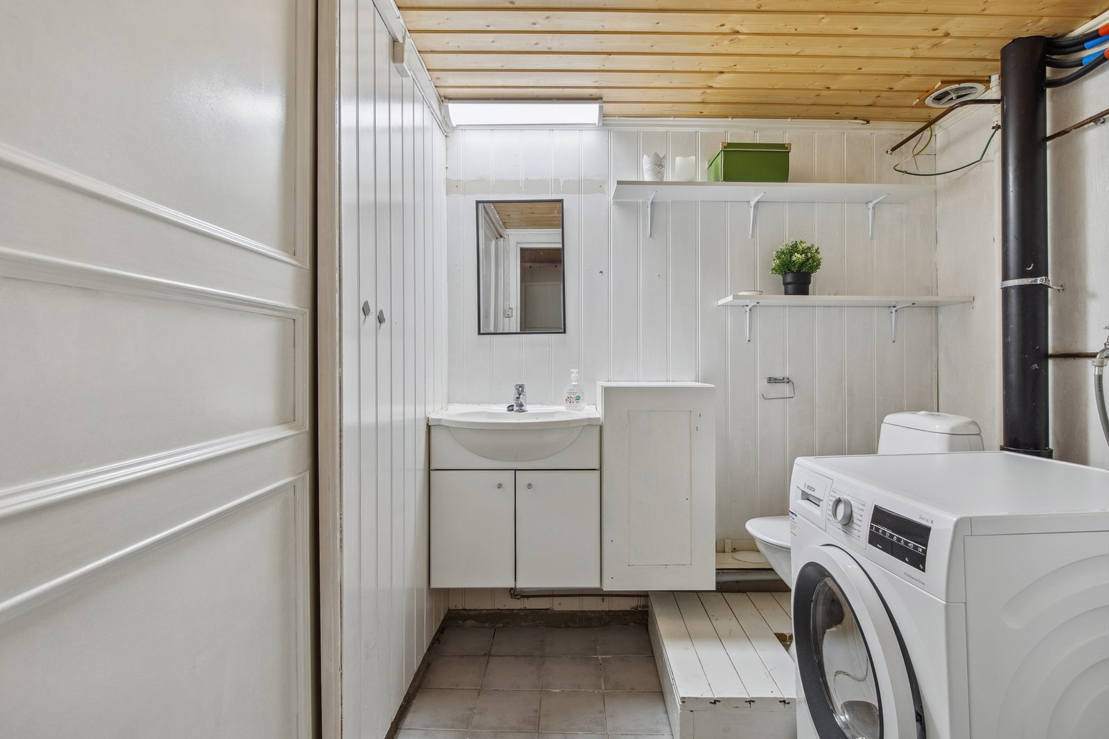 Vaskerom som også er kombinert med WC. Flislagt gulv, vegger kledd med trepanel og malt mur, samt trepanel i himlingen. Galleribilde