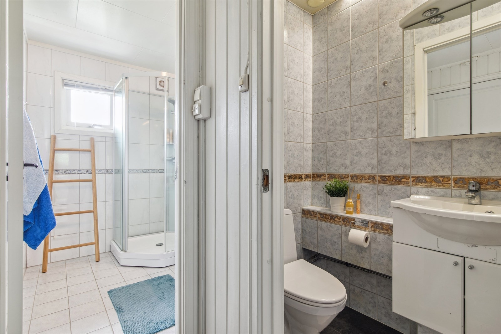 Separat og praktisk toalettrom som er innredet med toalett og en servantinnredning med underskap og et speilskap. Galleribilde