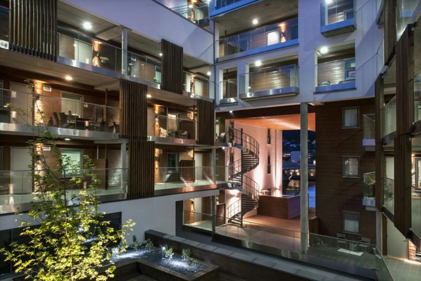 Atrium med spennende arkitektur med stor åpning i fasaden mot elva Galleribilde