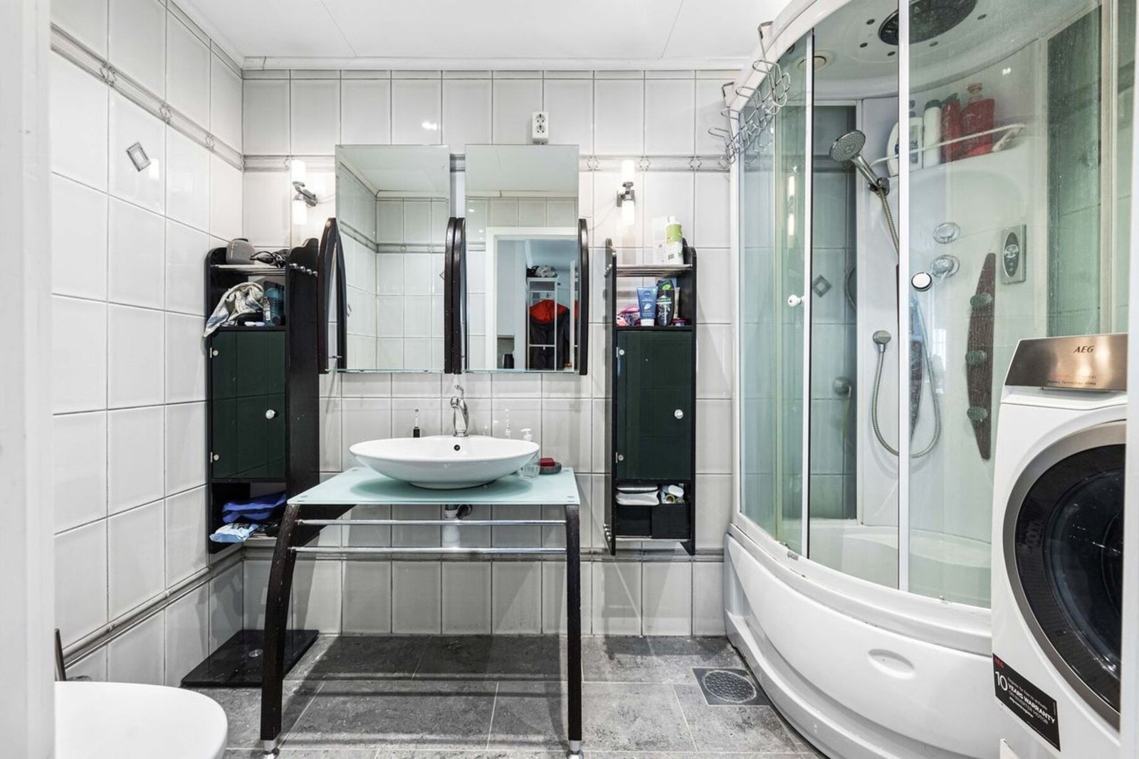 Badet er innredet med dusjkabinett, toalett, servant og opplegg for vaskemaskin. Galleribilde