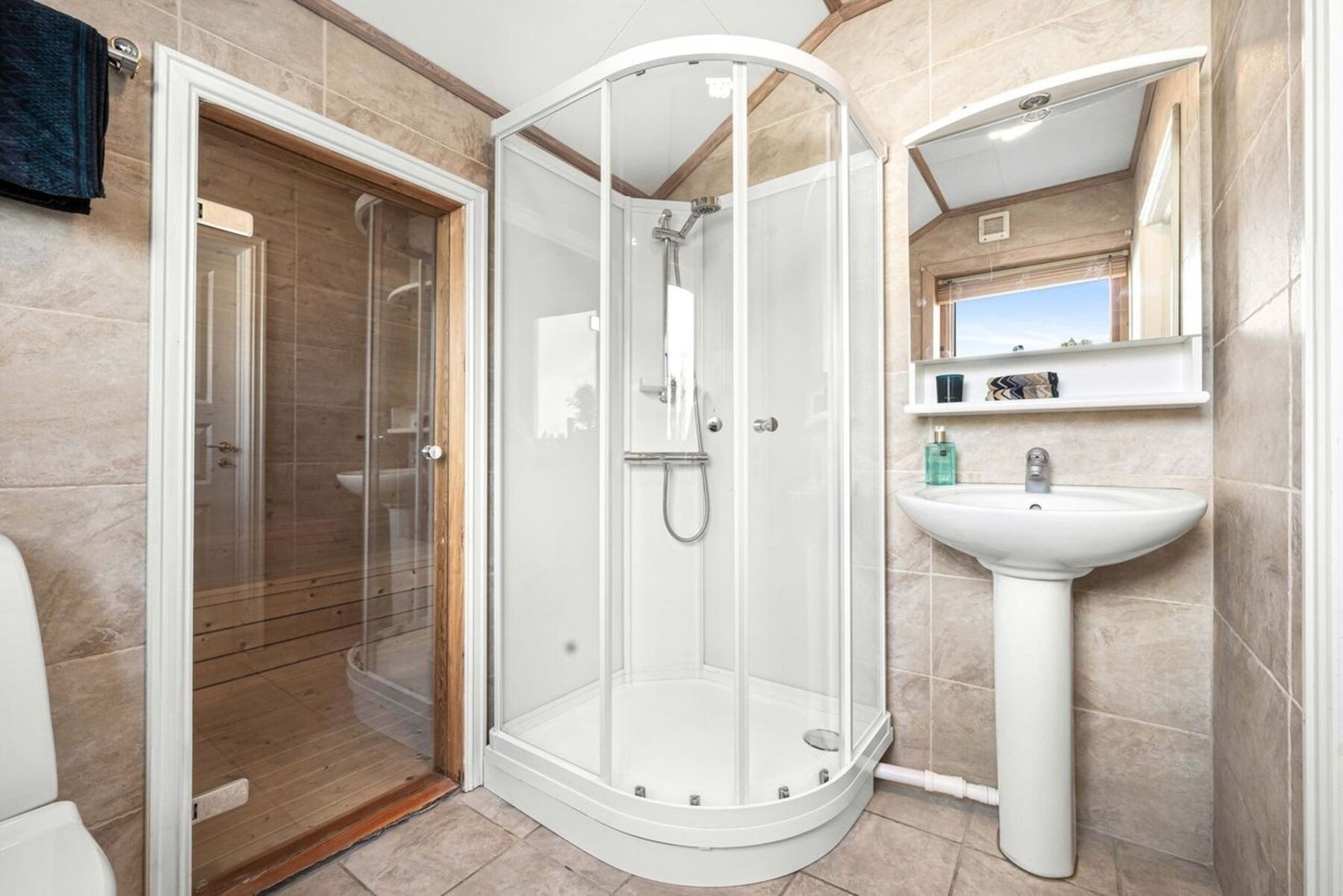 Badet er innredet med toalett, dusjkabinett og servant. Galleribilde