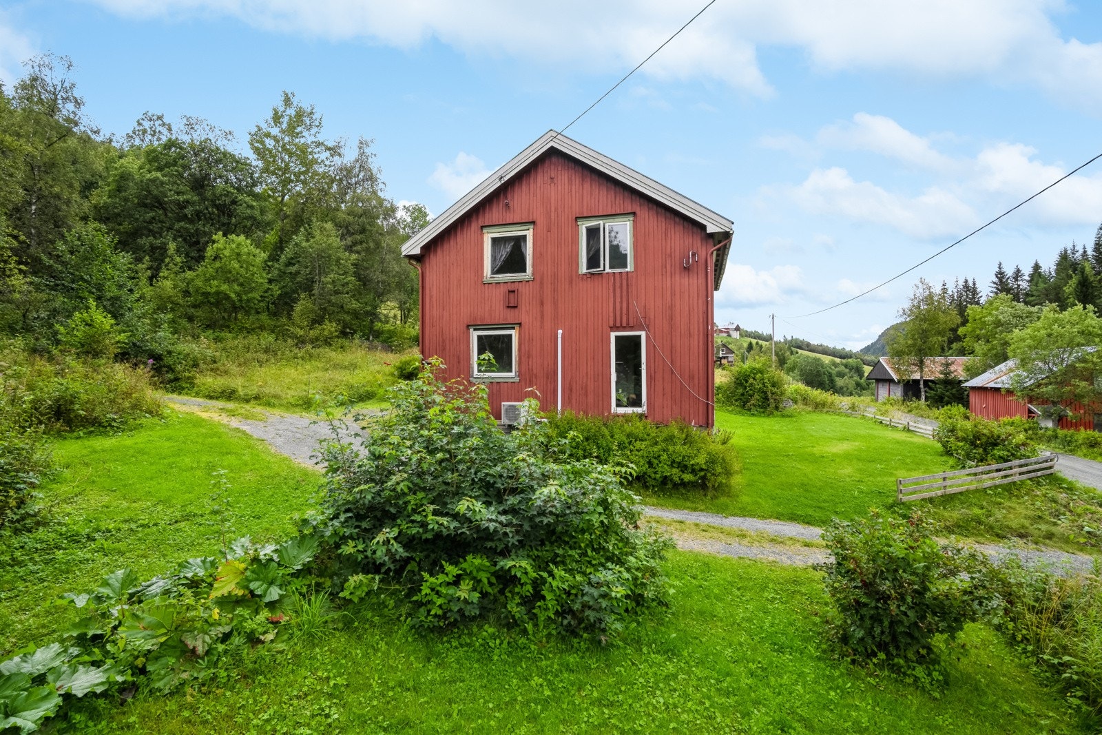 Tomt opparbeidet med gruslagte veier, diverse beplantninger, plenareal og biloppstillingsplass. Frittstående vedbod. Galleribilde