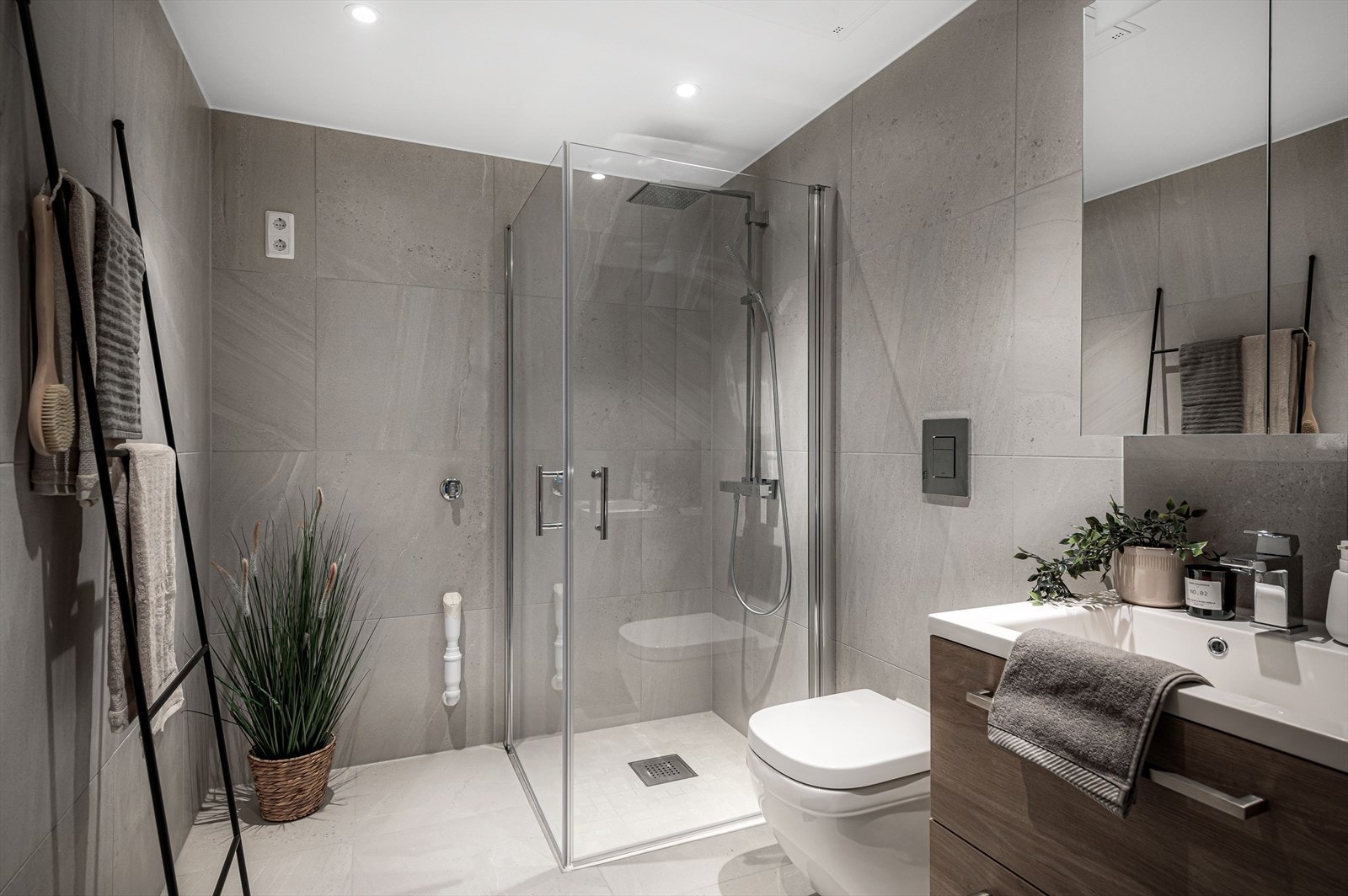 Flislagt baderom 2 med varmekabler i gulv og dimbare downlights i himling. Baderomsinnredningen fra Bano Home med hvit servant, speilskap, vegghengt toalett med softclose, dusjvegger, servantarmatur fra Grohe Eurocube og dusjsett fra Grohe Eurocube. Galleribilde