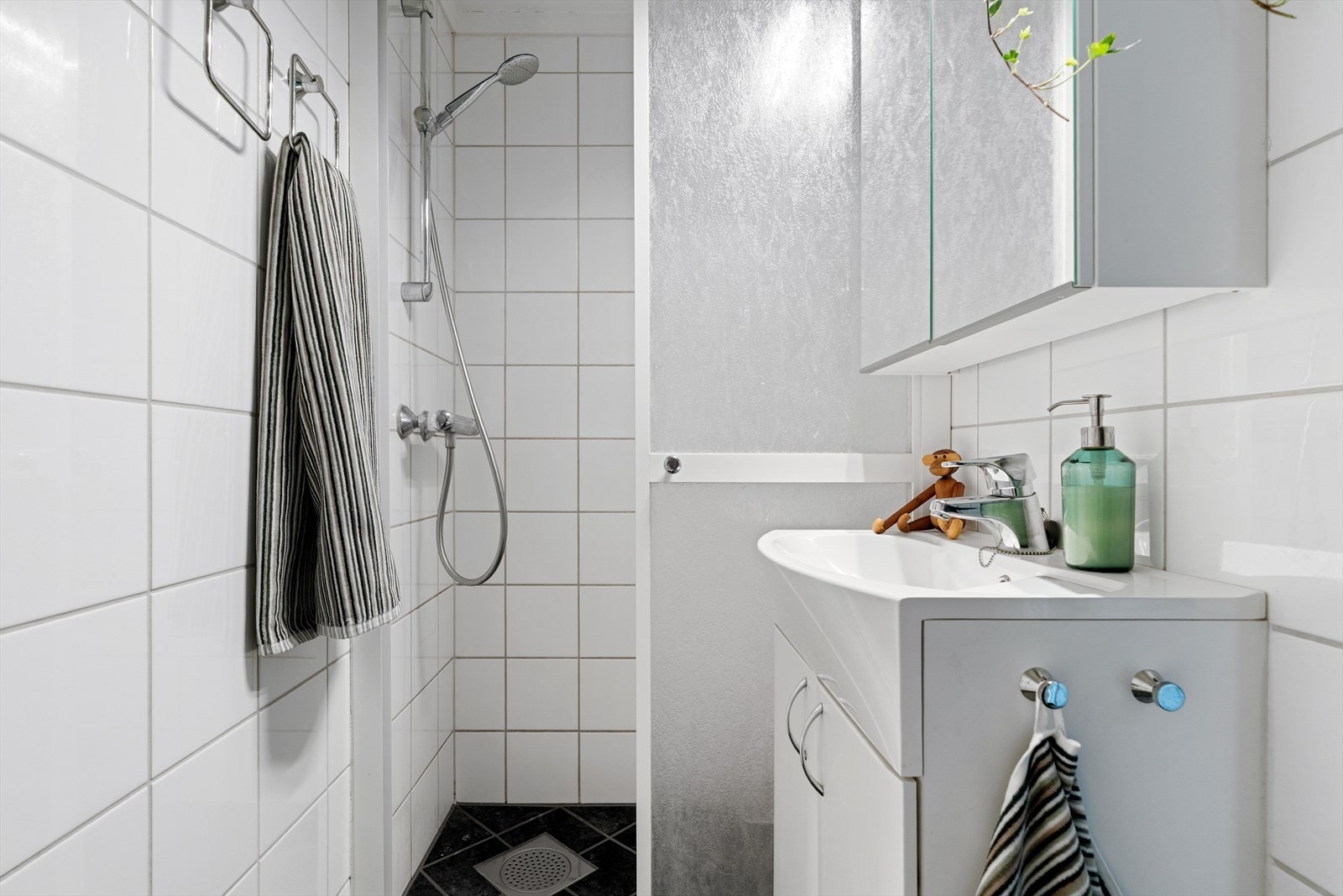 Badet er flislagt og innredet i nøytrale farger som gjør det enkelt å supplere med dekor av egen stil og smak. Varmekabler i gulv. Galleribilde