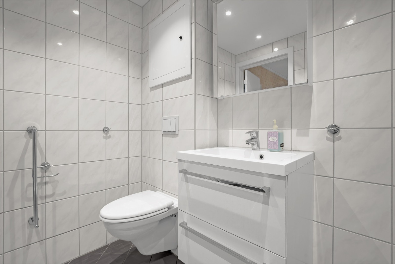 Badet har varmekabler i gulv, downlights i tak og opplegg for vaskemaskin Galleribilde