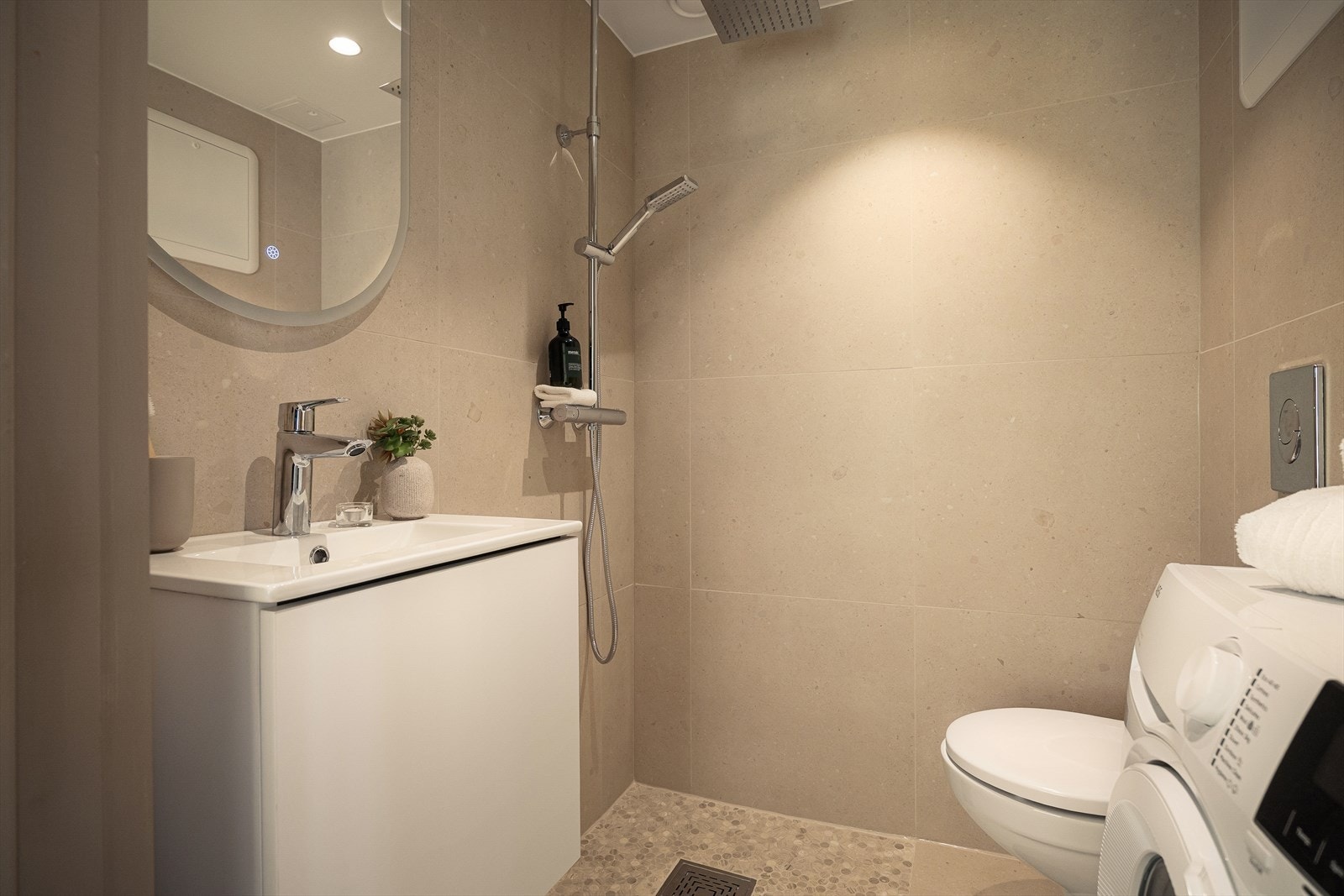 Nypusset bad (2025) med moderne fliser, varmekabler og ny baderomsinnredning med glatte fronter. Galleribilde