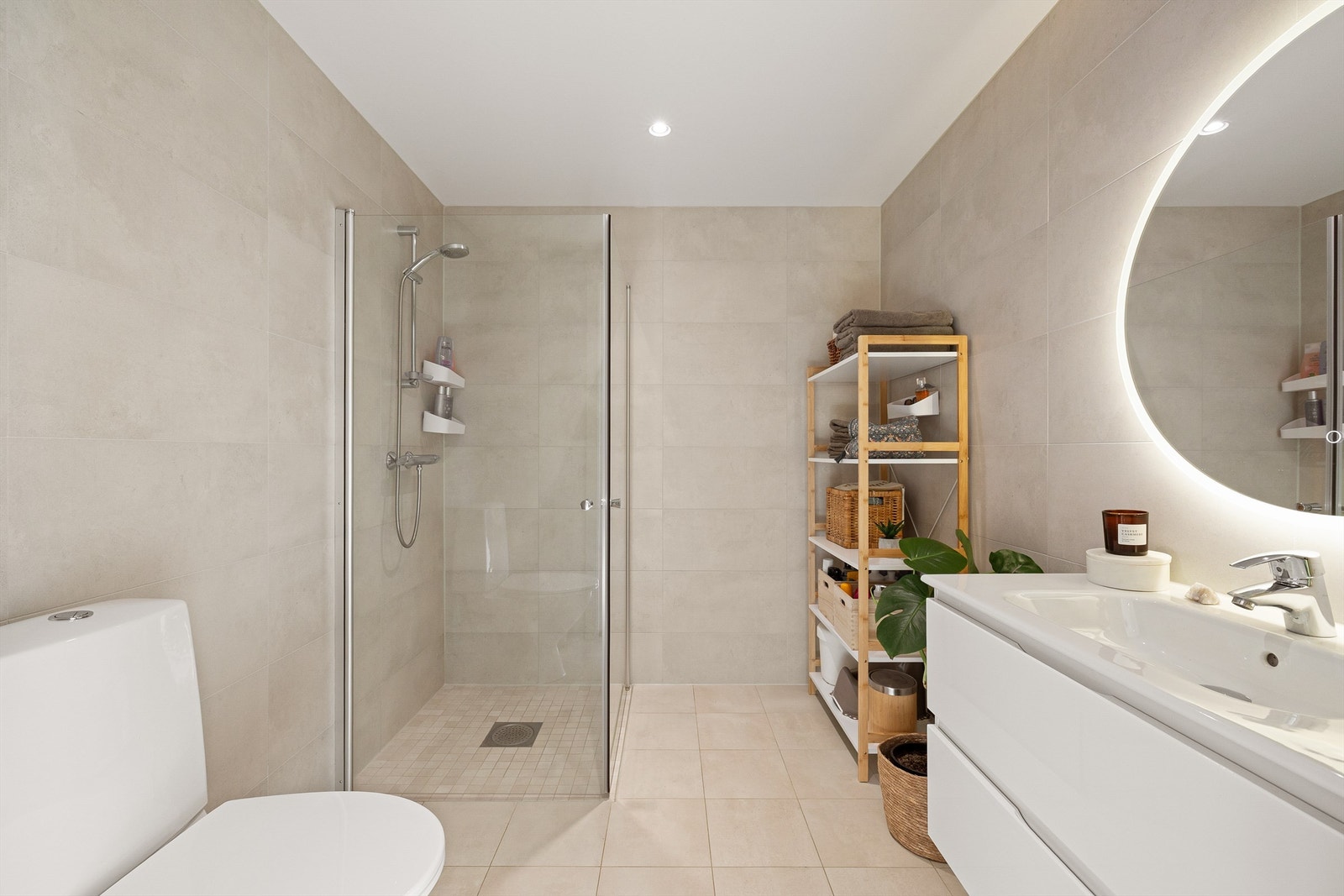 Badet har lyse fliser, åpen dusj og behagelig belysning som gir en rolig atmosfære. Galleribilde