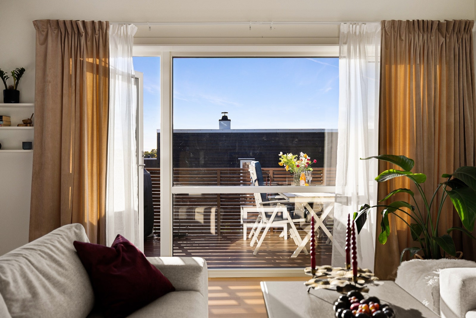 Stuen bader i naturlig lys fra det brede vinduspartiet. Galleribilde