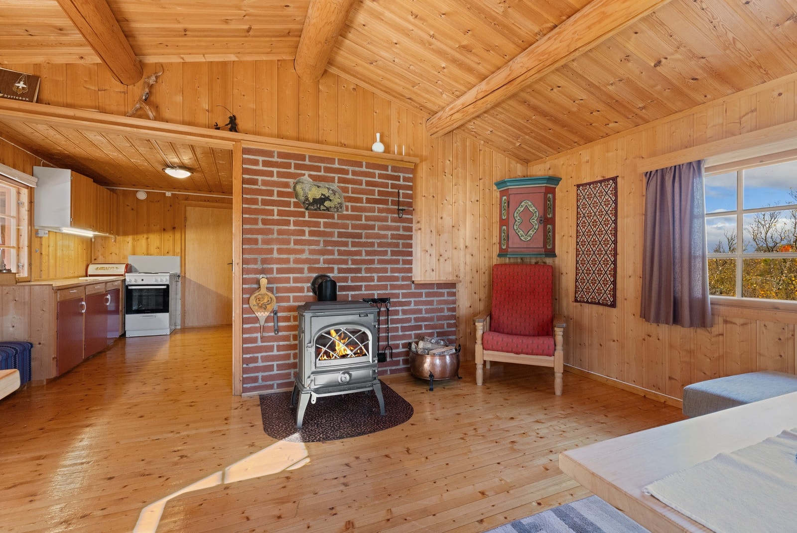 Teglsteinsmur og Jøtul vedovn som gir langvarig varme Galleribilde