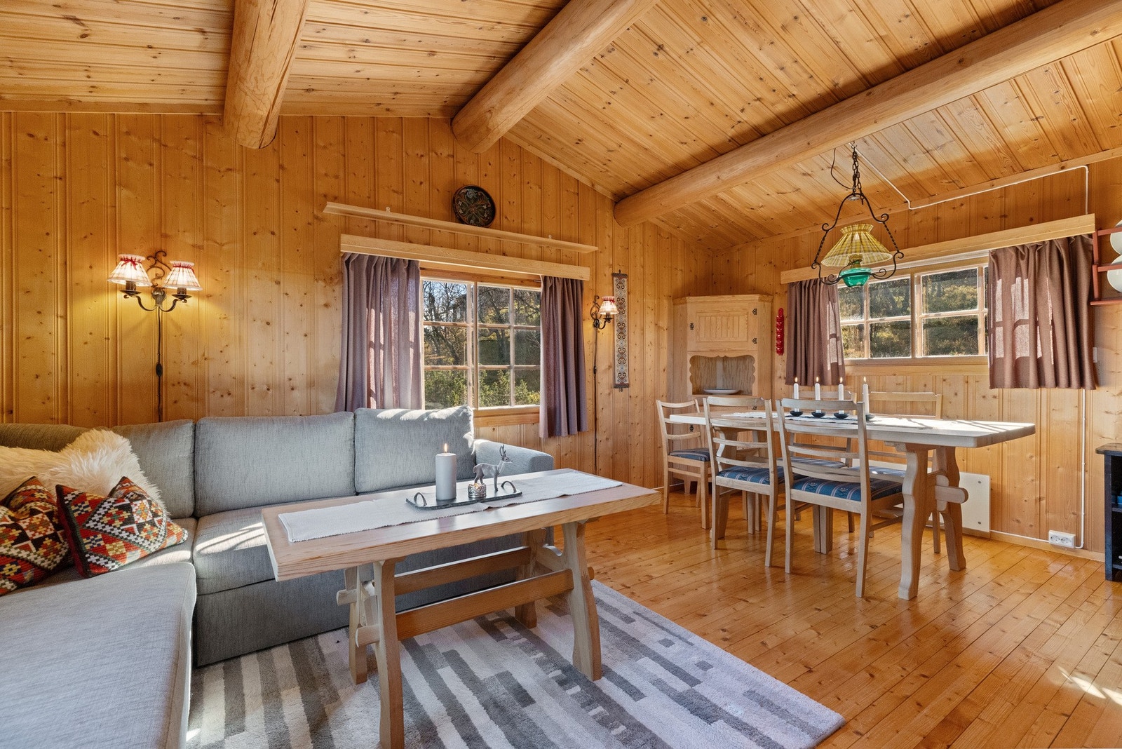 Hytta byr på ei koselig stue med rausta tak og tømmeråser Galleribilde